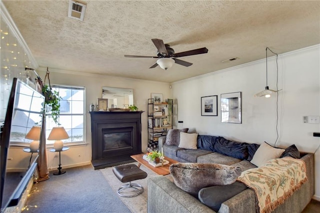 carpeted living room with a textured ceiling, ceiling fan, and crown molding