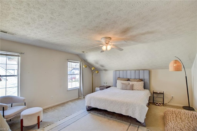 bedroom with ceiling fan, multiple windows, a textured ceiling, and lofted ceiling