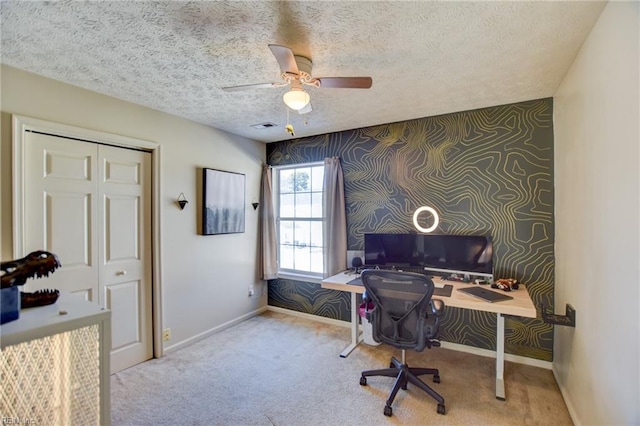 home office with a textured ceiling, ceiling fan, and light colored carpet