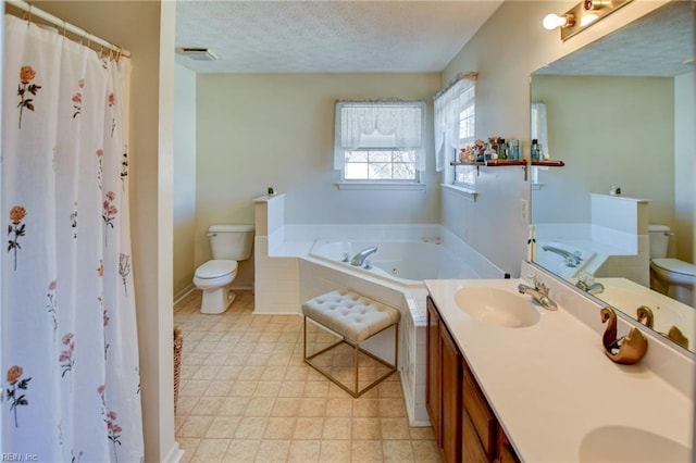 bathroom featuring toilet, vanity, a textured ceiling, and tiled tub