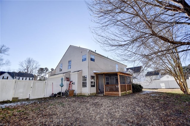 rear view of property featuring a sunroom