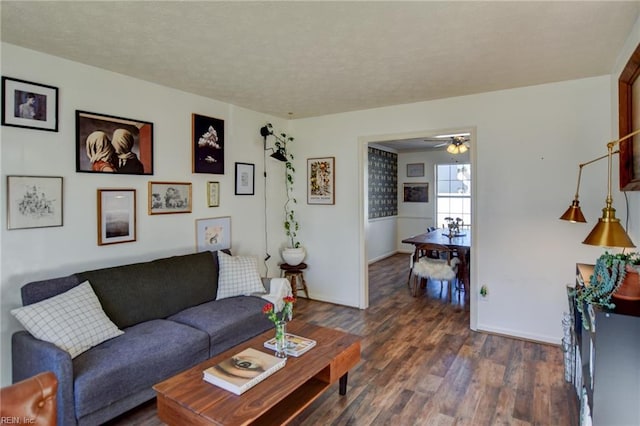 living room featuring ceiling fan and dark hardwood / wood-style floors