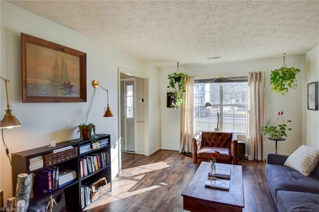 living room with dark wood-type flooring and a textured ceiling