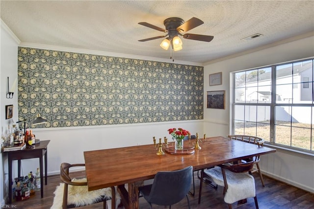 dining area featuring dark wood-type flooring, ceiling fan, ornamental molding, and a healthy amount of sunlight