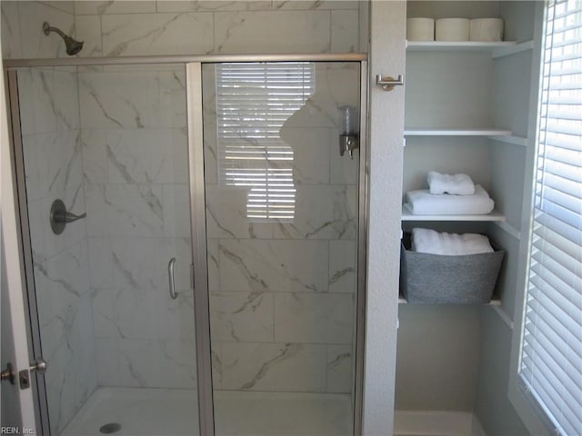 bathroom with a wealth of natural light and a shower with door