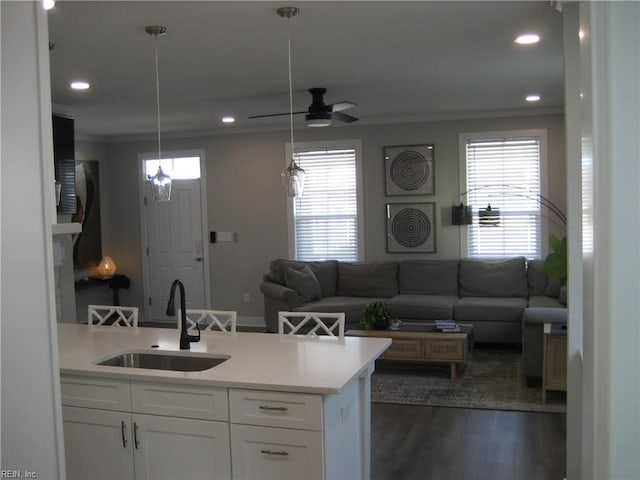 kitchen featuring hanging light fixtures, white cabinetry, sink, and a wealth of natural light