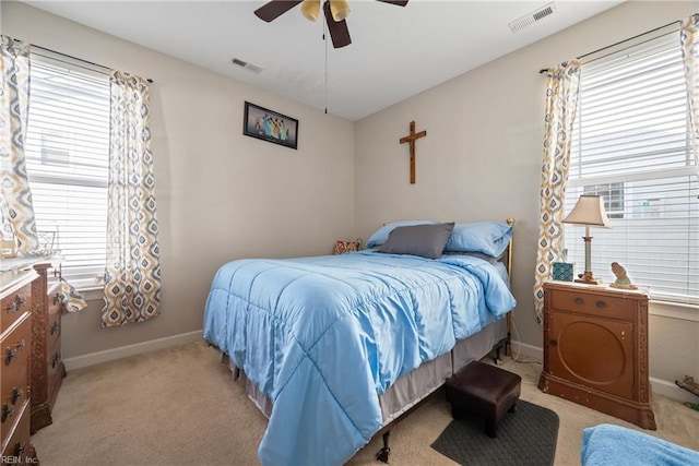 carpeted bedroom featuring multiple windows and ceiling fan