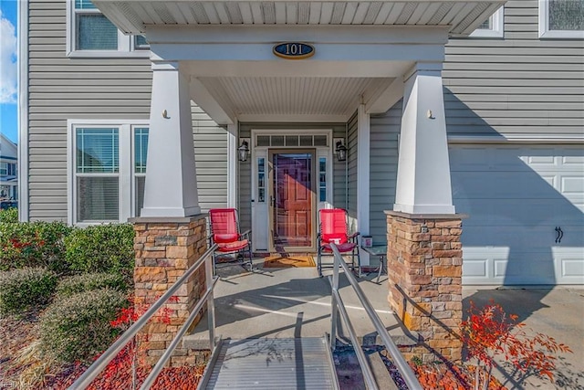 view of exterior entry with a porch and a garage