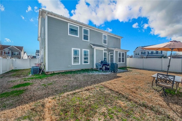 rear view of house with a yard and central AC unit