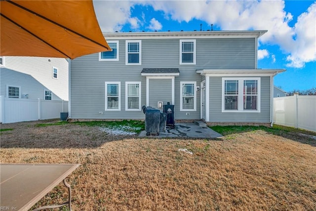 rear view of property with a lawn and a patio