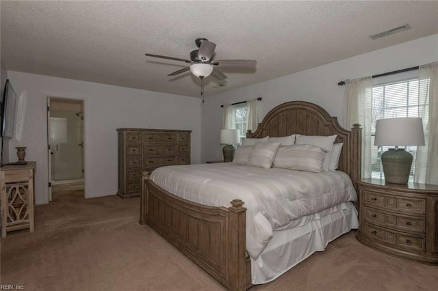 bedroom with light carpet, ceiling fan, and a textured ceiling