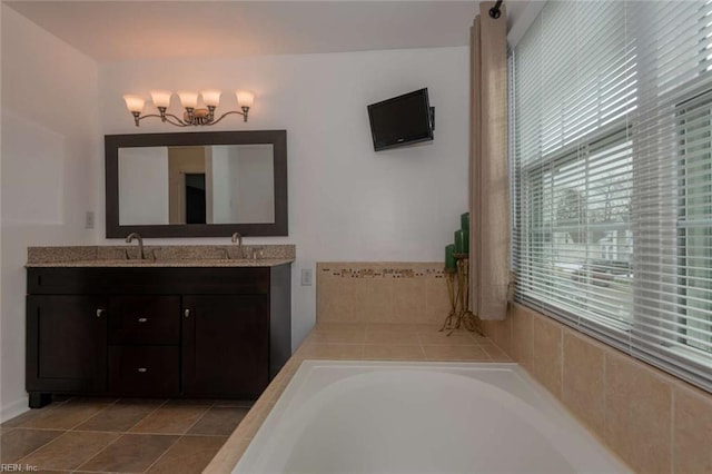 bathroom with tiled bath, vanity, and tile patterned floors