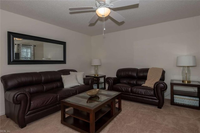 living room featuring ceiling fan, light carpet, and a textured ceiling