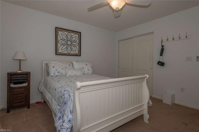 bedroom with ceiling fan, a closet, and light carpet