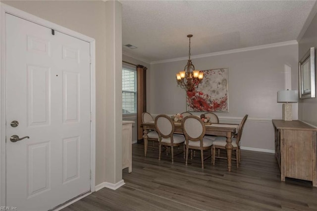 dining room featuring a textured ceiling, dark hardwood / wood-style flooring, crown molding, and an inviting chandelier