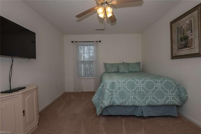 carpeted bedroom with a textured ceiling and ceiling fan