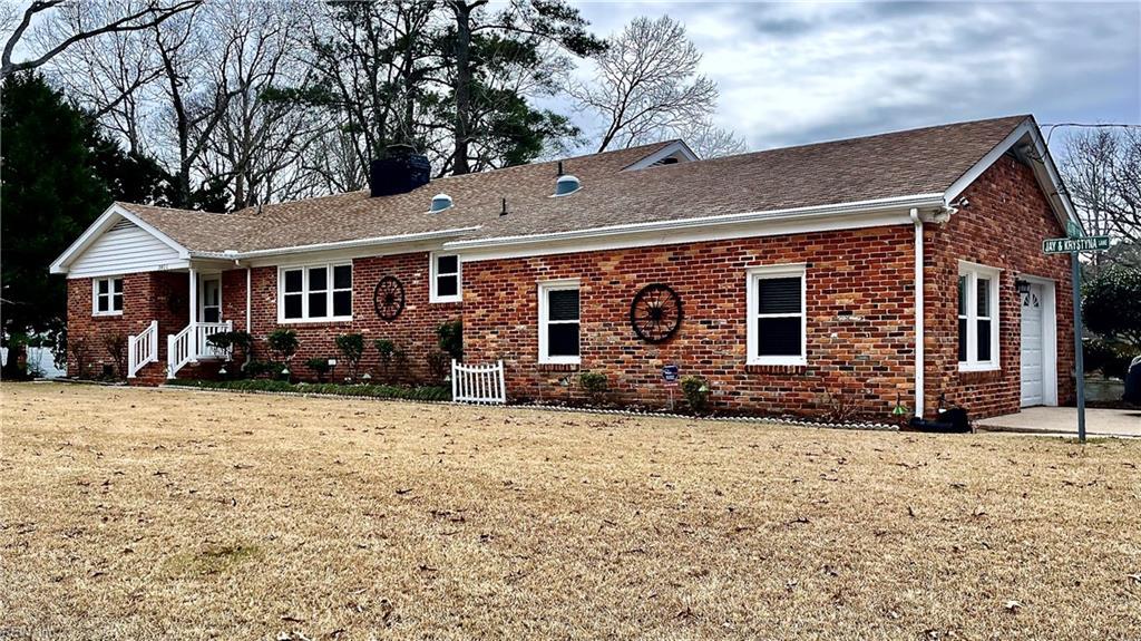 rear view of house featuring a garage and a yard