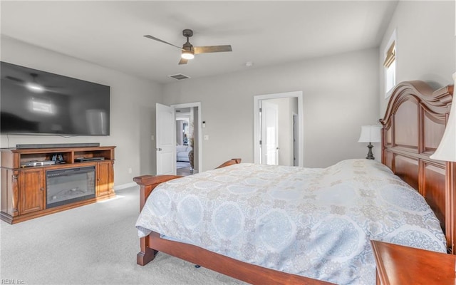 bedroom with light carpet, ceiling fan, and ensuite bathroom