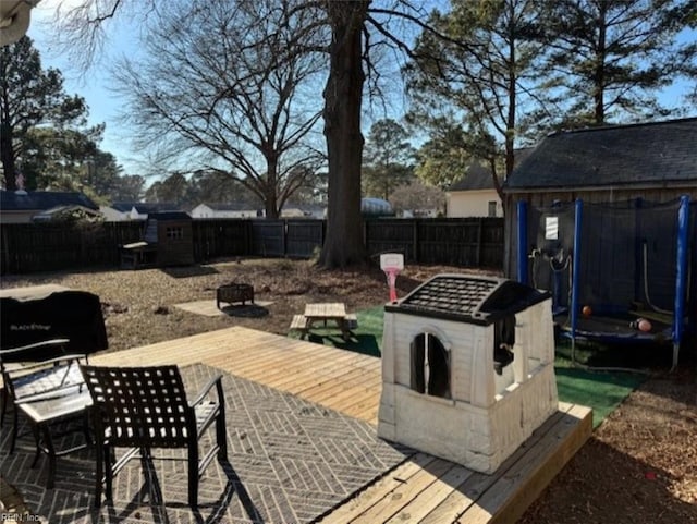 view of patio with a trampoline and an outdoor fire pit