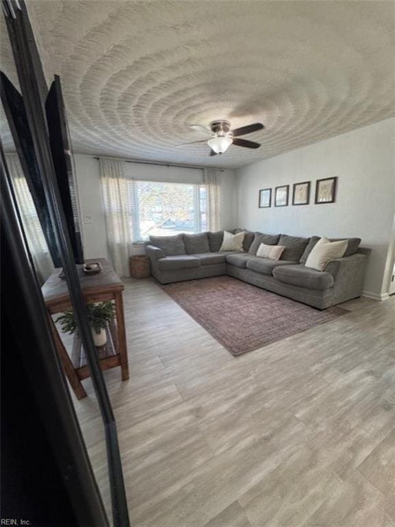 living room featuring ceiling fan and light hardwood / wood-style floors