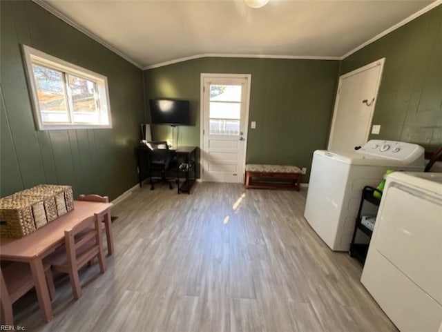 clothes washing area with light wood-type flooring, washer and dryer, and ornamental molding