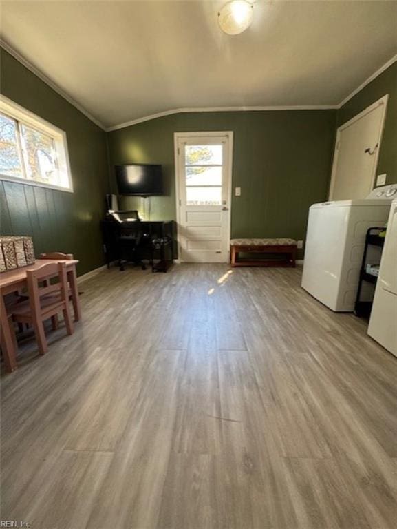 living room featuring washer / dryer, ornamental molding, lofted ceiling, and light hardwood / wood-style floors