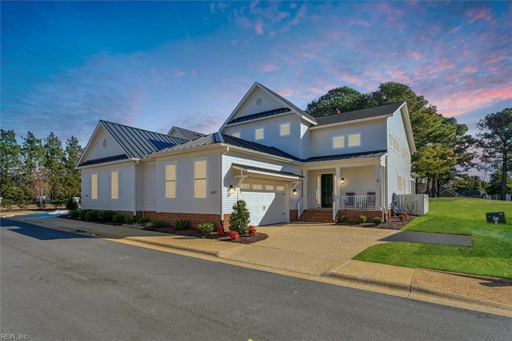 view of front of home featuring a garage, a porch, and a lawn