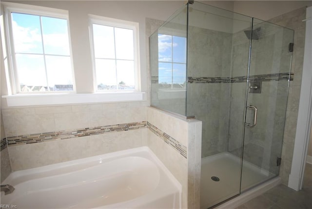 bathroom with separate shower and tub and tile patterned flooring