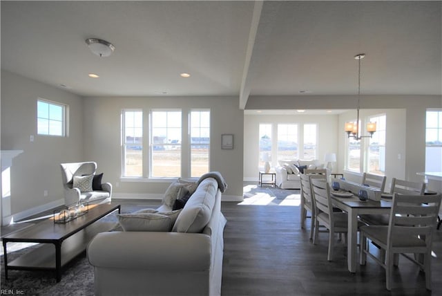 living room with dark hardwood / wood-style floors, beamed ceiling, and an inviting chandelier