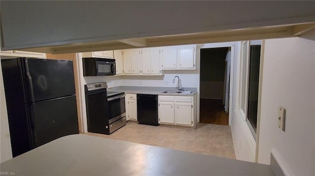 kitchen with sink, white cabinets, black appliances, and light tile patterned flooring