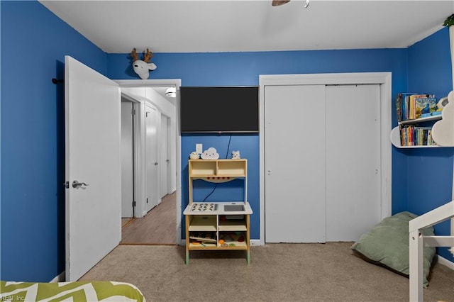 bedroom with ceiling fan, carpet, and a closet