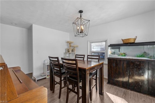 dining room with wood-type flooring and a notable chandelier