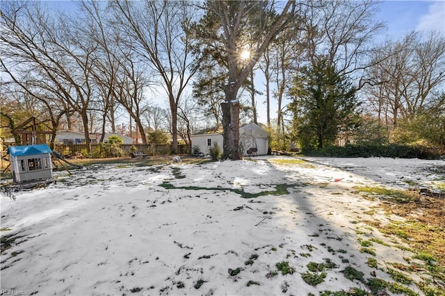 yard layered in snow featuring a playground and an outdoor structure