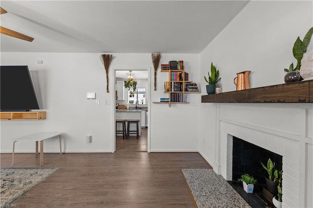 living room with a brick fireplace and dark hardwood / wood-style floors