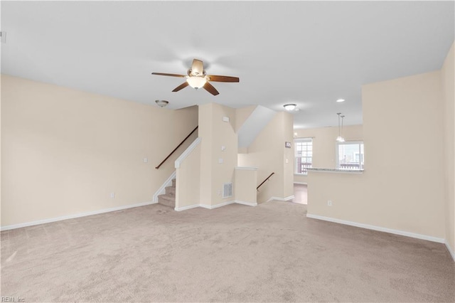 unfurnished living room featuring light carpet and ceiling fan