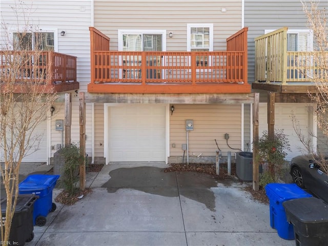 back of house with a garage and central air condition unit