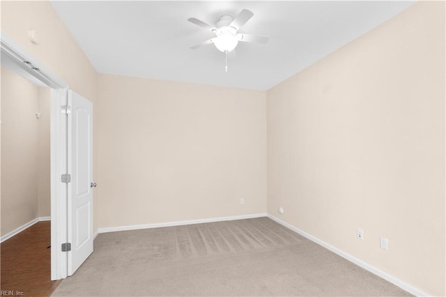 empty room featuring ceiling fan and light carpet