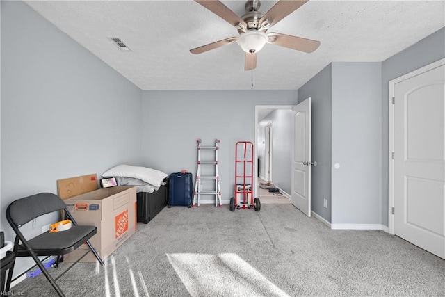 bedroom with ceiling fan, a textured ceiling, and carpet flooring