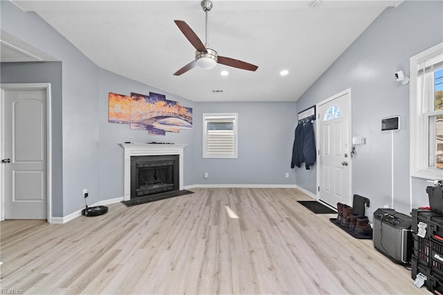 living room featuring ceiling fan, light hardwood / wood-style flooring, and lofted ceiling