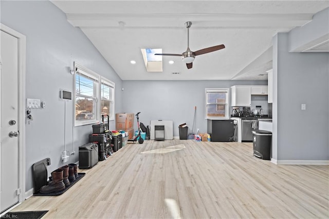 interior space featuring light wood-type flooring, vaulted ceiling with skylight, and ceiling fan