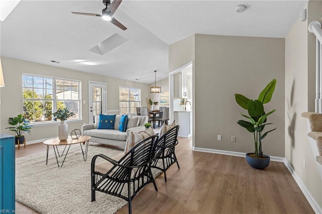 living room featuring ceiling fan and hardwood / wood-style floors