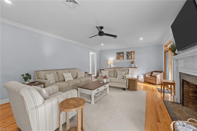 living room featuring light wood-type flooring, ceiling fan, and ornamental molding