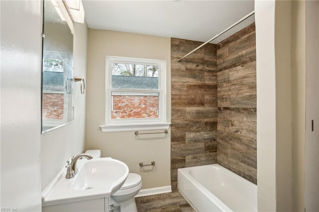 full bathroom with toilet, tiled shower / bath, hardwood / wood-style flooring, and sink