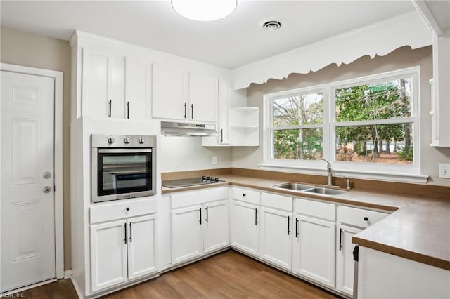 kitchen with hardwood / wood-style floors, white cabinetry, black electric stovetop, sink, and stainless steel oven