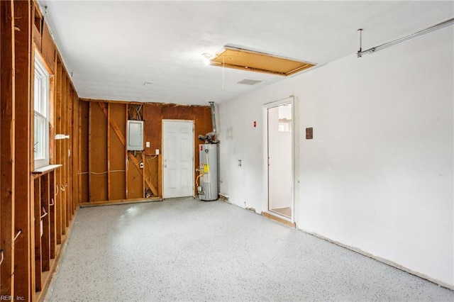 garage with electric panel, wooden walls, and gas water heater