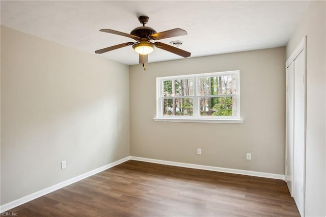 unfurnished bedroom with ceiling fan and dark wood-type flooring