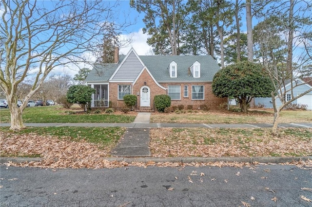 cape cod house featuring a front yard