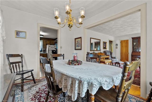 dining area with an inviting chandelier and hardwood / wood-style floors