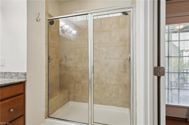 bathroom featuring walk in shower and vanity