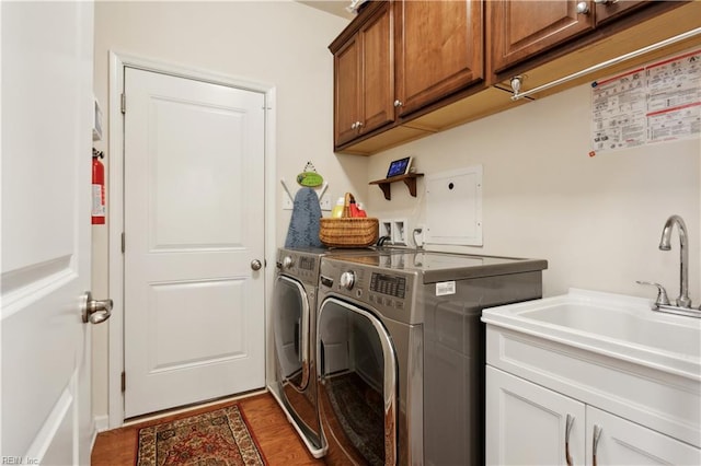 clothes washing area featuring cabinets, dark hardwood / wood-style floors, sink, and washing machine and dryer